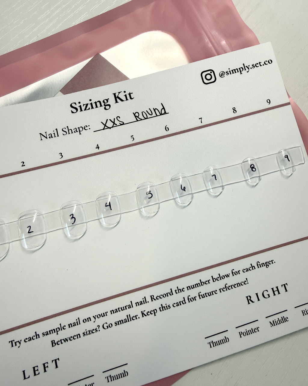 Simply Set sizing kit card with numbered clear sample nails, shown with its pink branded pouch